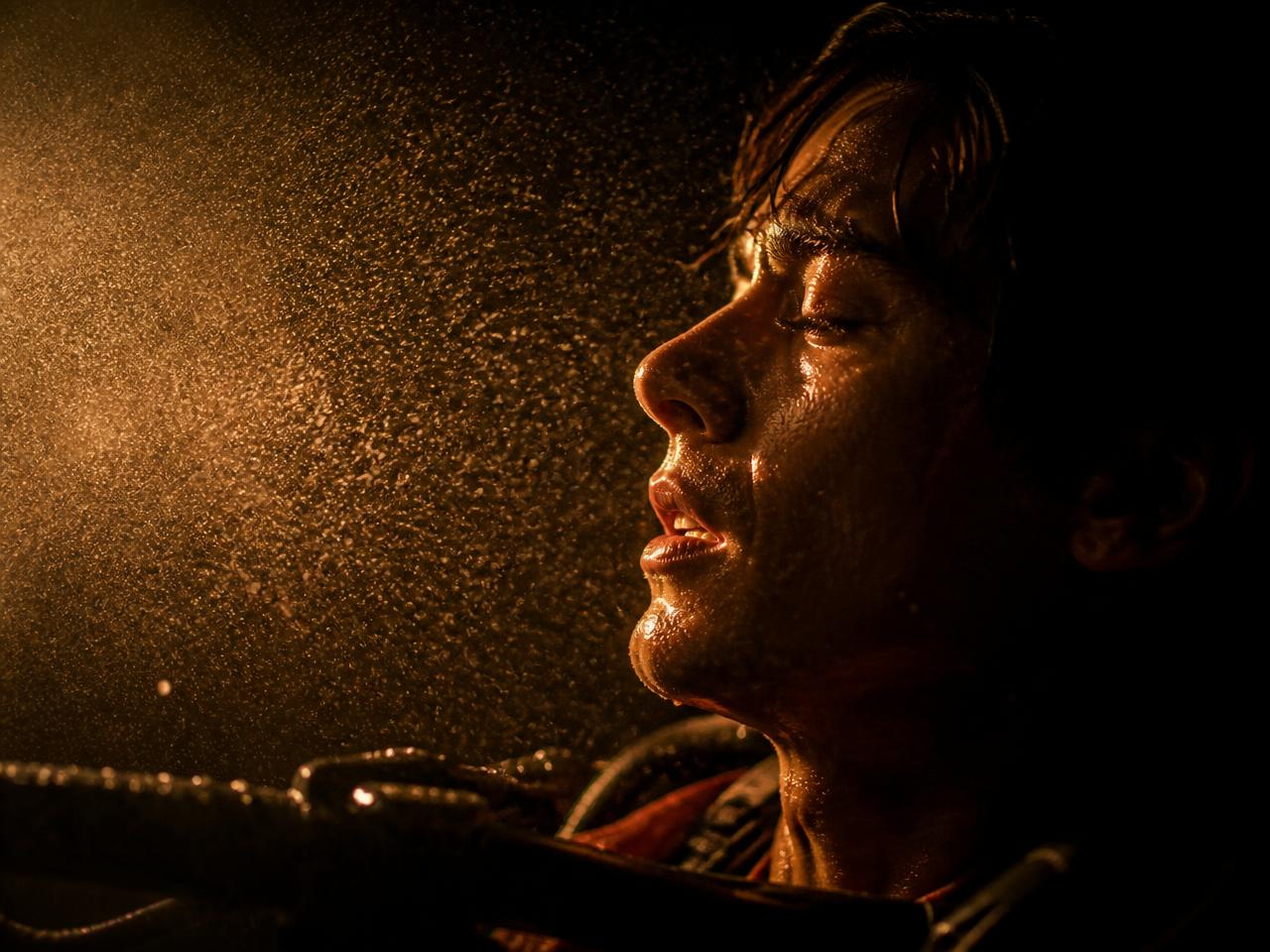 Fine mist and moving air caught in a beam of light inside a dark theater